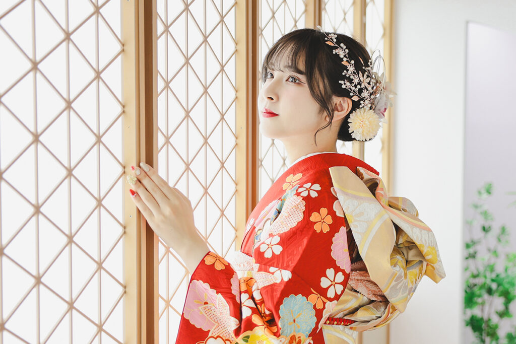 赤い振袖を着て前撮り撮影をする女性