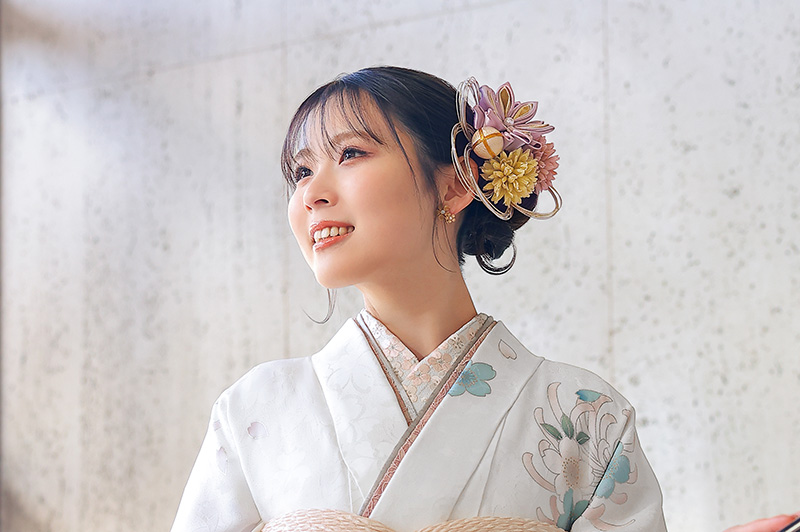 白い振袖を着たつまみ細工とドライフラワーの髪飾りの女性